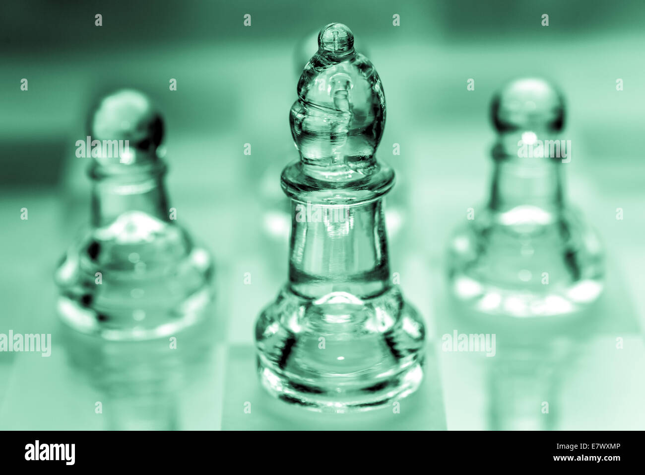 Bishop chess piece with pawns in the background pieces made out of glass Stock Photo