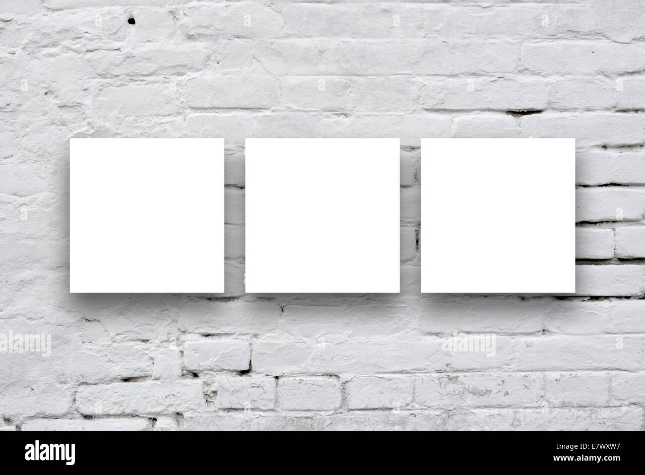 Three Square Posters hanging on the art gallery white wall. Stock Photo