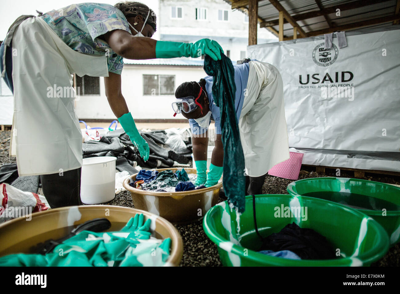 Health workers clean hospital scrubs and protective gear at the newly opened Island Clinic for Ebola treatment September 22, 2014 in Monrovia, Liberia. The facility opened by the WHO and the Ministry of Health in response to the surge of patients needing an Ebola Treatment. Stock Photo