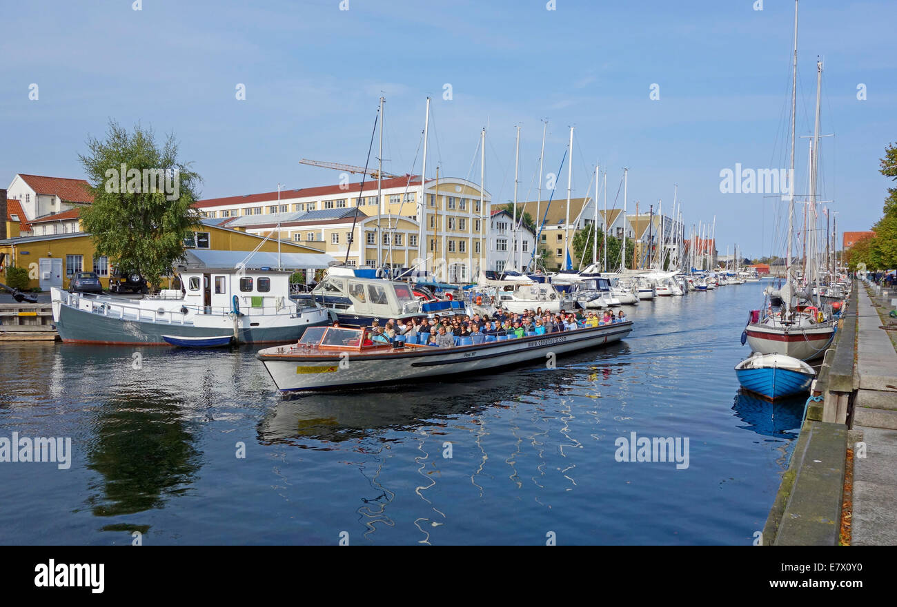 Christianshavn Canal in Copenhagen Denmark with vessels along both quays and canaltours harbour cruise vessel passing through Stock Photo