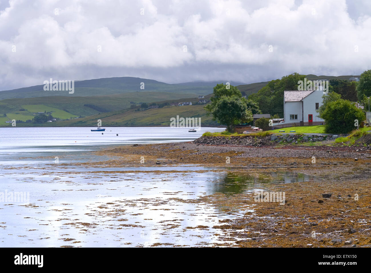 A small white croft on the shore of Loch Harport, Carbost, on the Isle of Skye. Stock Photo
