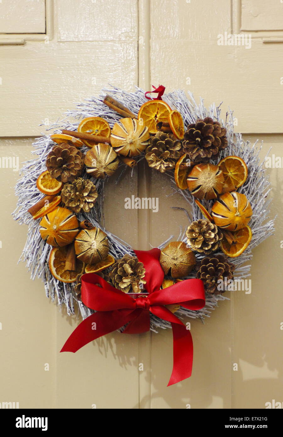 Natural Christmas wreath featuring dried fruits & cinnamon sticks hangs on a painted wooden door, Peak District Derbyshire UK Stock Photo