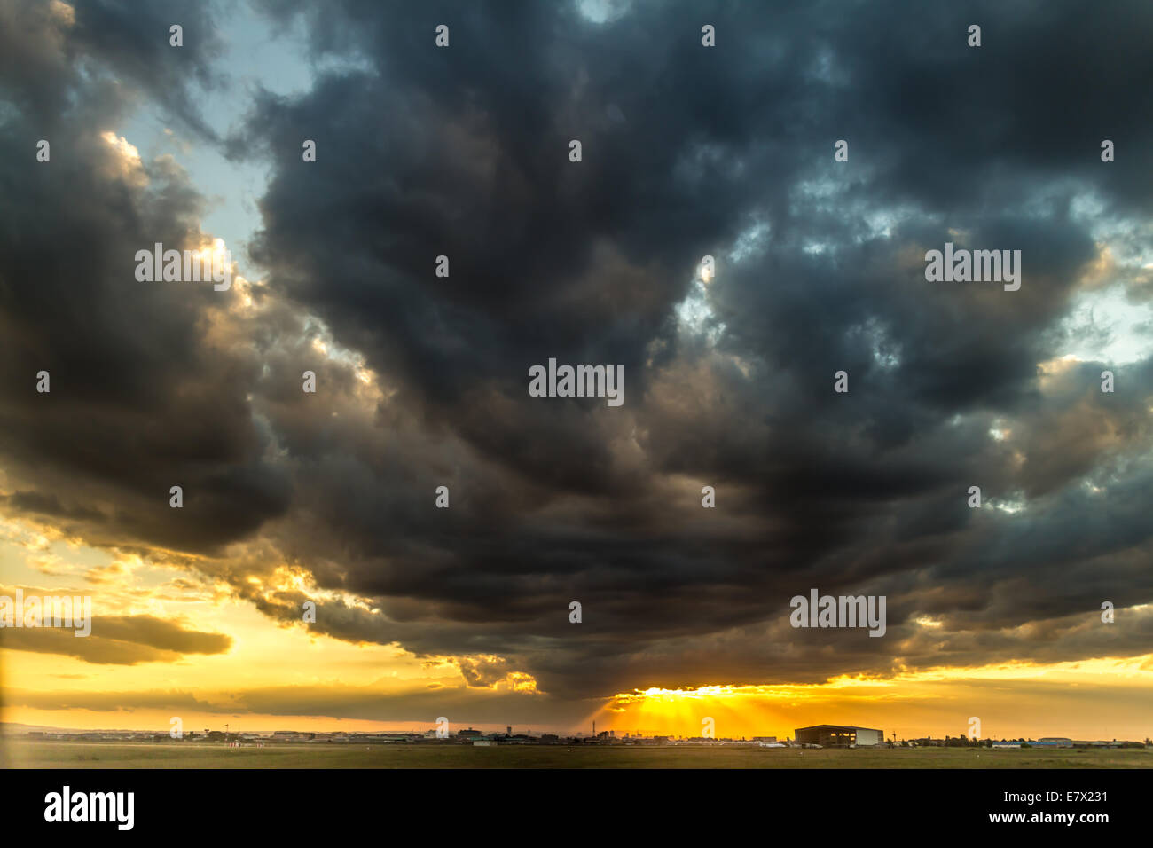 The last rays of the sunset breaking through the stormy clouds over the ...