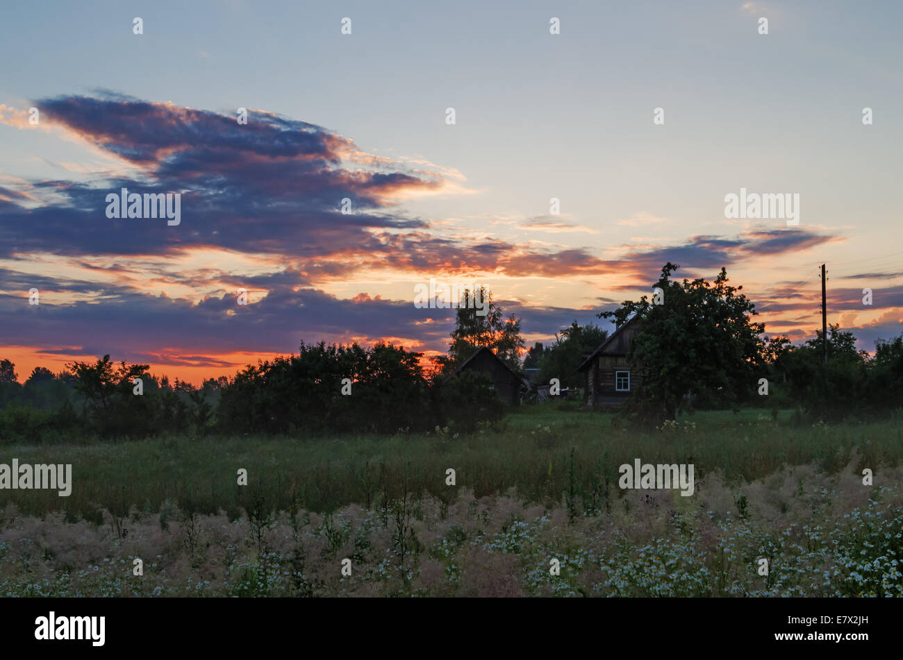 Sunrise over field and houses Stock Photo - Alamy