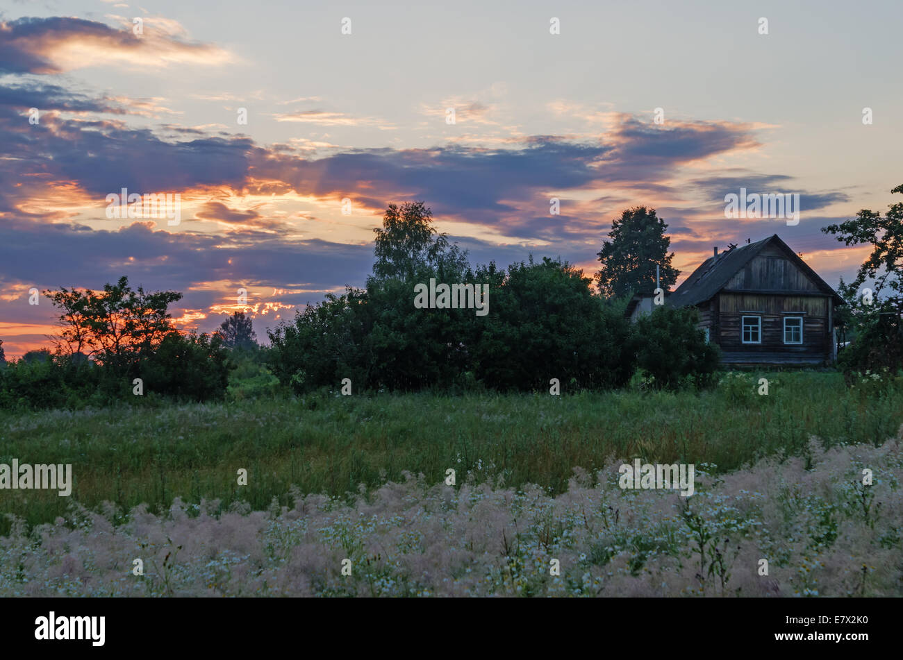 Sunrise over field and houses Stock Photo - Alamy