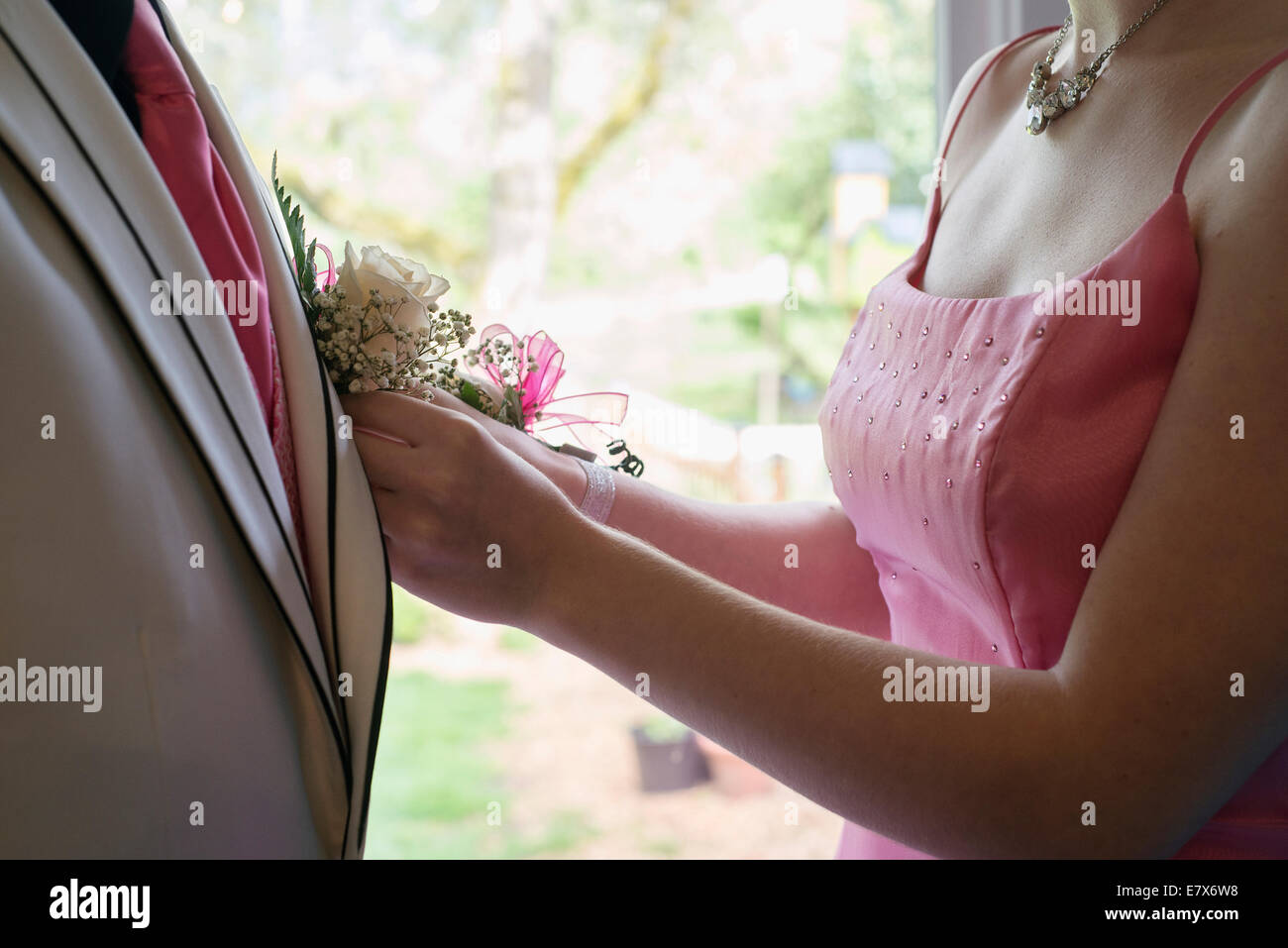 A girl pinning a Boutineer on her prom date. Stock Photo