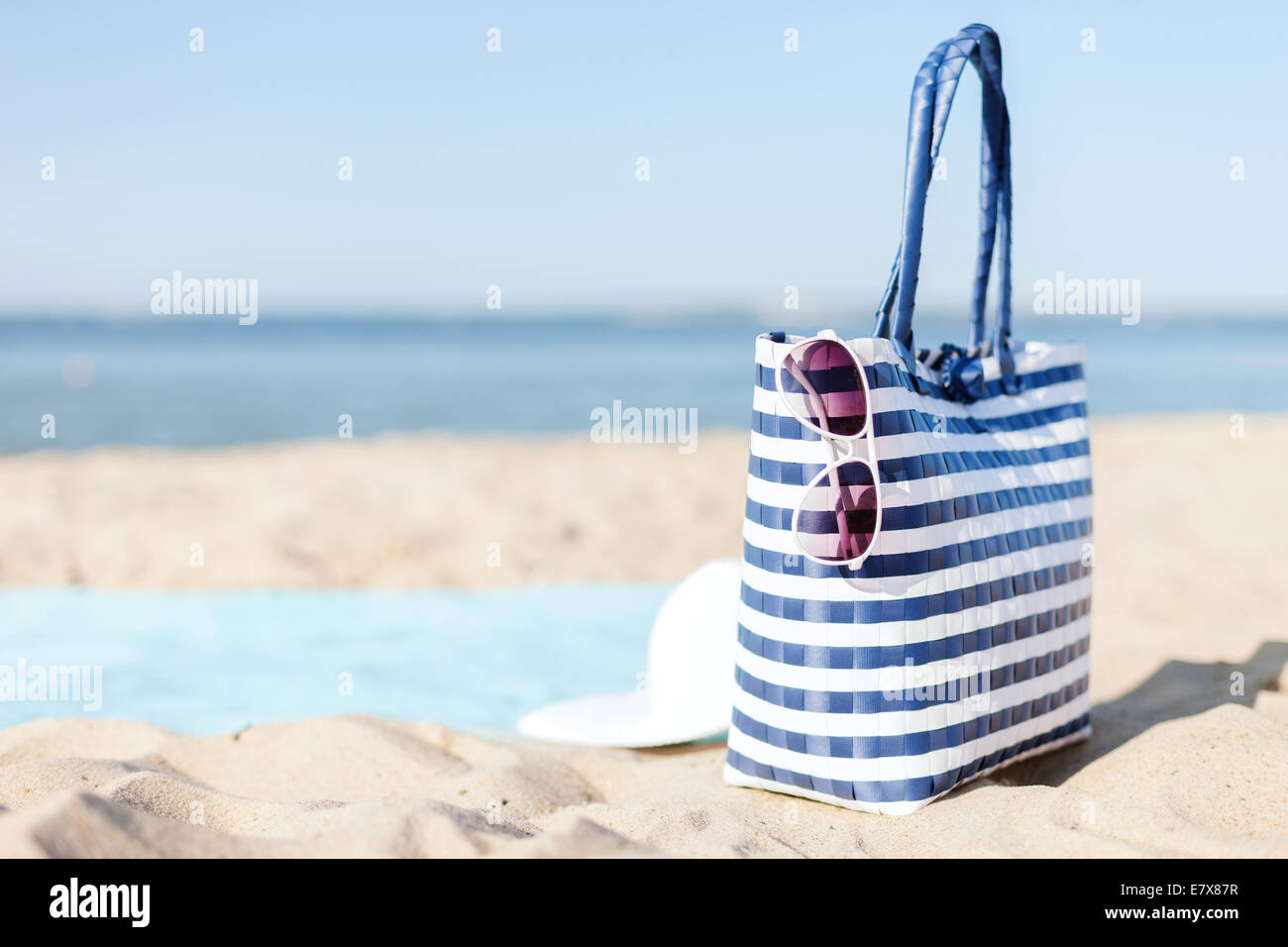 straw hat, sunglasses and bag lying in the sand Stock Photo - Alamy