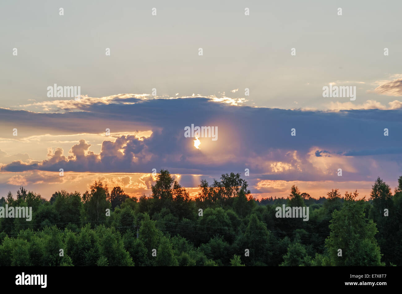 Sunset - the sun shines through a cloud Stock Photo - Alamy
