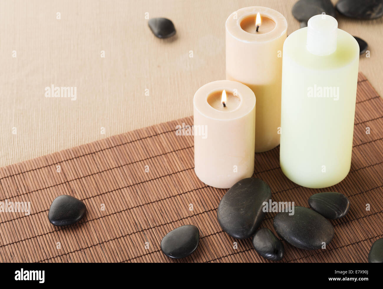 shampoo bottle, massage stones and candles Stock Photo