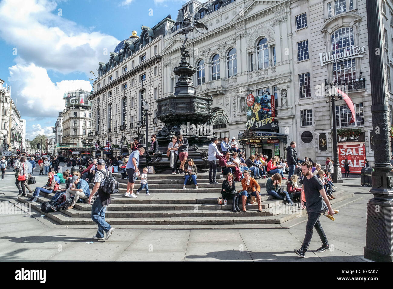 Piccadilly Circus,London, Tourists sit on the Steps of the Eros Statue Stock Photo