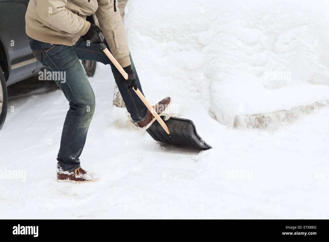 closeup of man shoveling snow from driveway Stock Photo