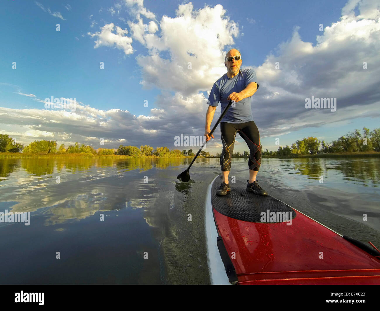 senior male paddler enjoying workout on stand up paddleboard (SUP), calm lake in Colorado, summer Stock Photo