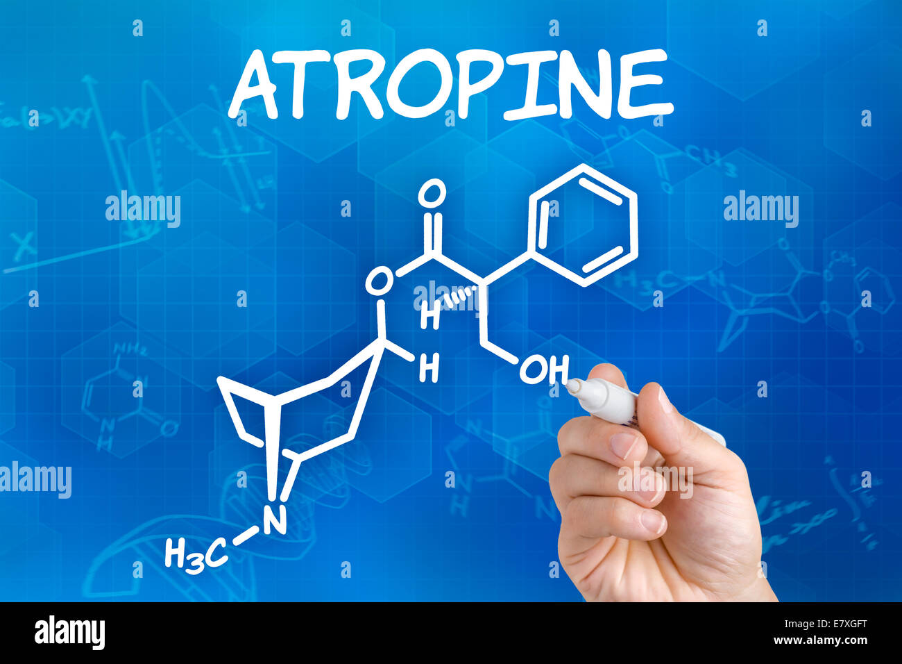 Hand with pen drawing the chemical formula of Atropine Stock Photo