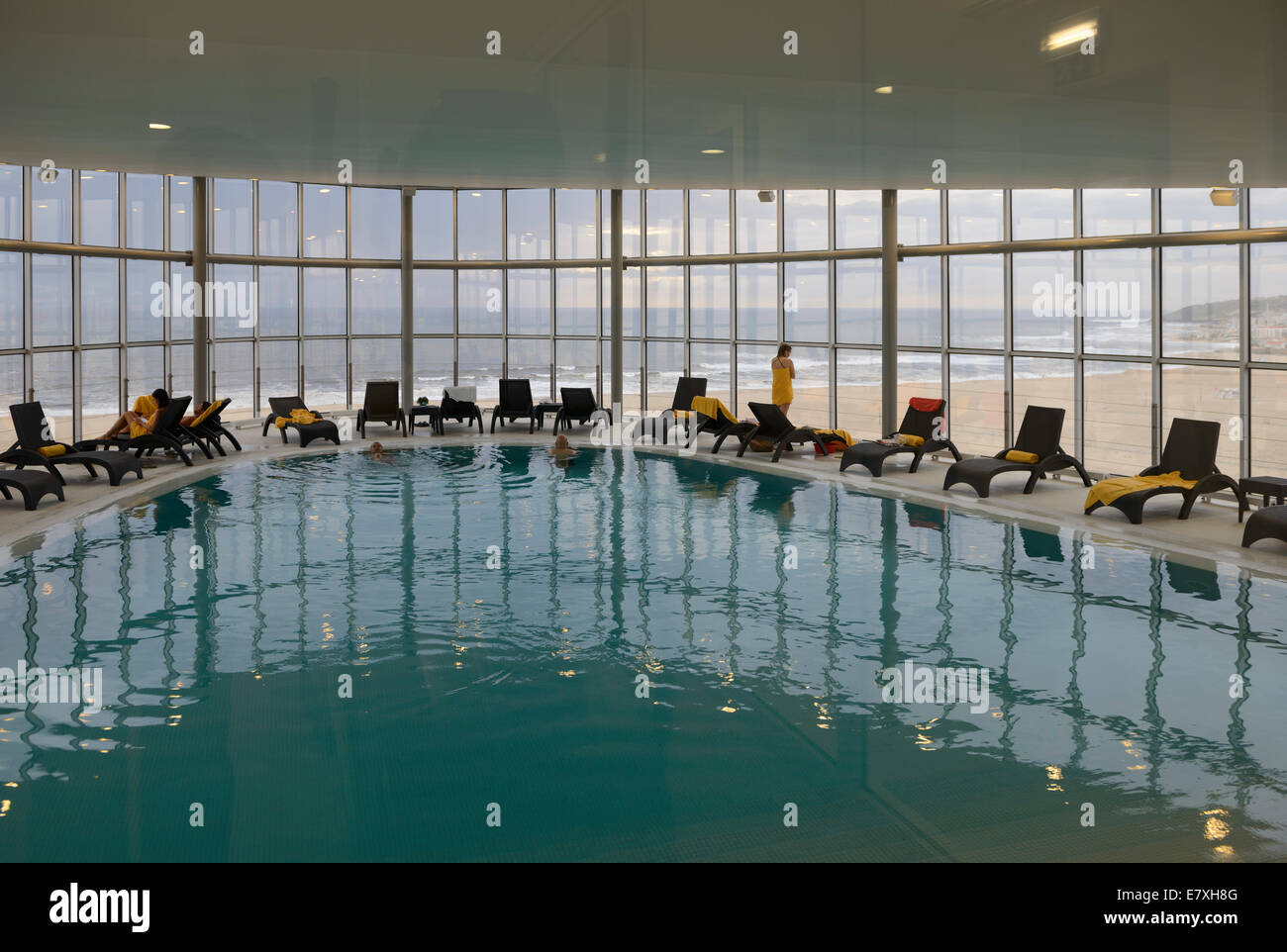 Hotel indoor swimming pool with large window with a view to the beach Stock Photo