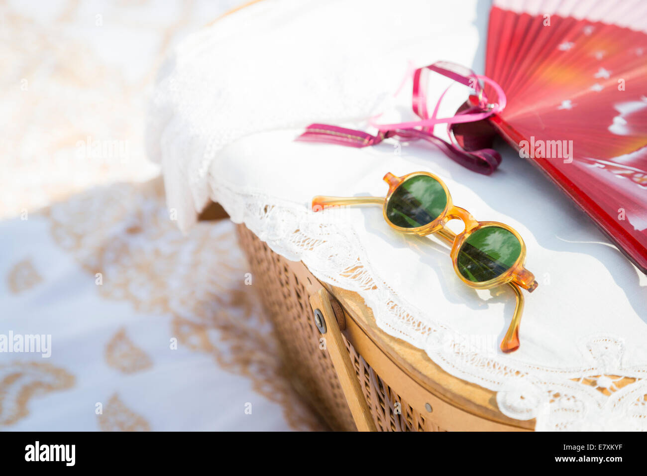 Stylish Sunglasses, Chinese Fan and Picnic Basket on Blanket Stock
