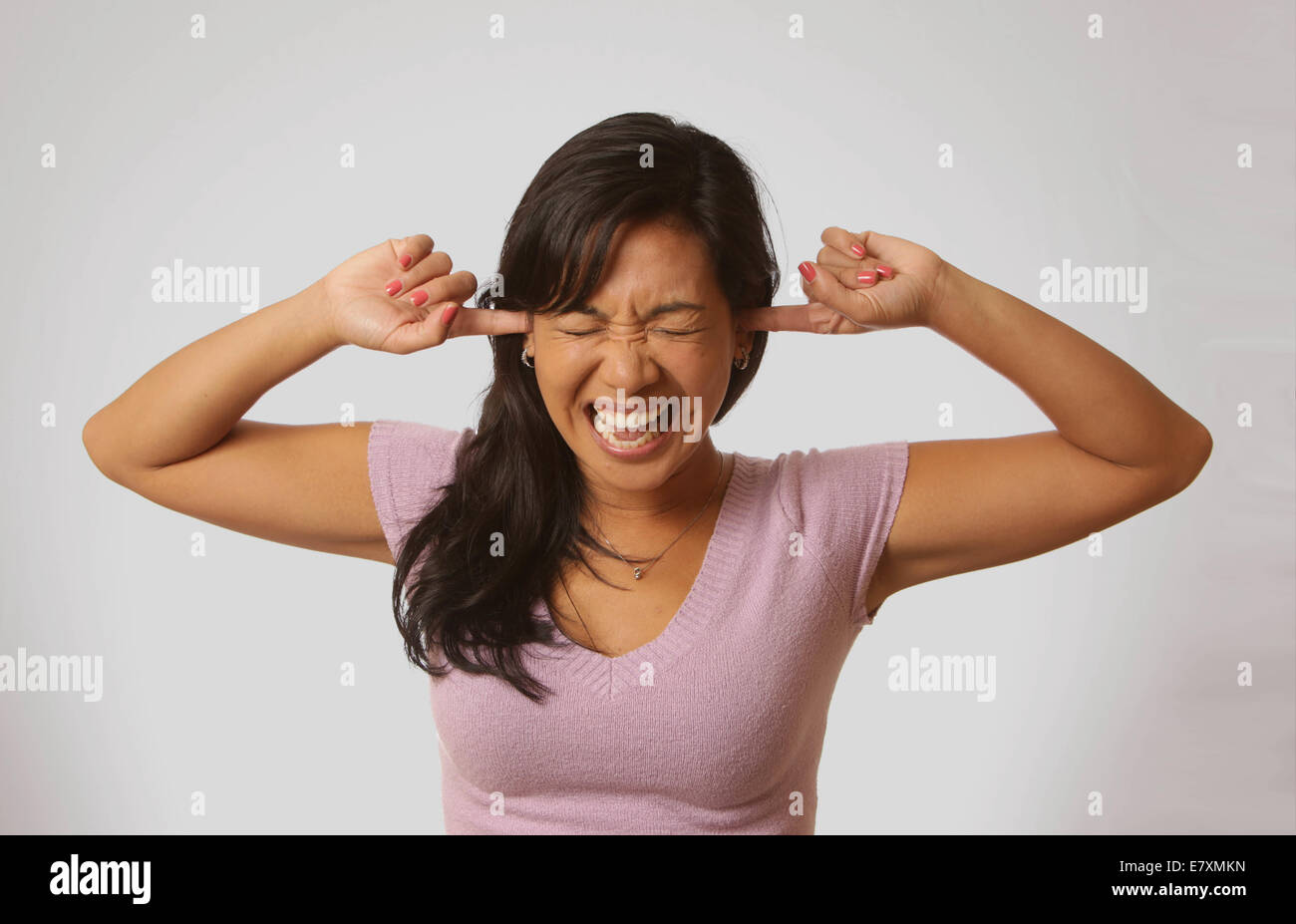 Beautiful woman with fingers in ears to block noise, New York, USA