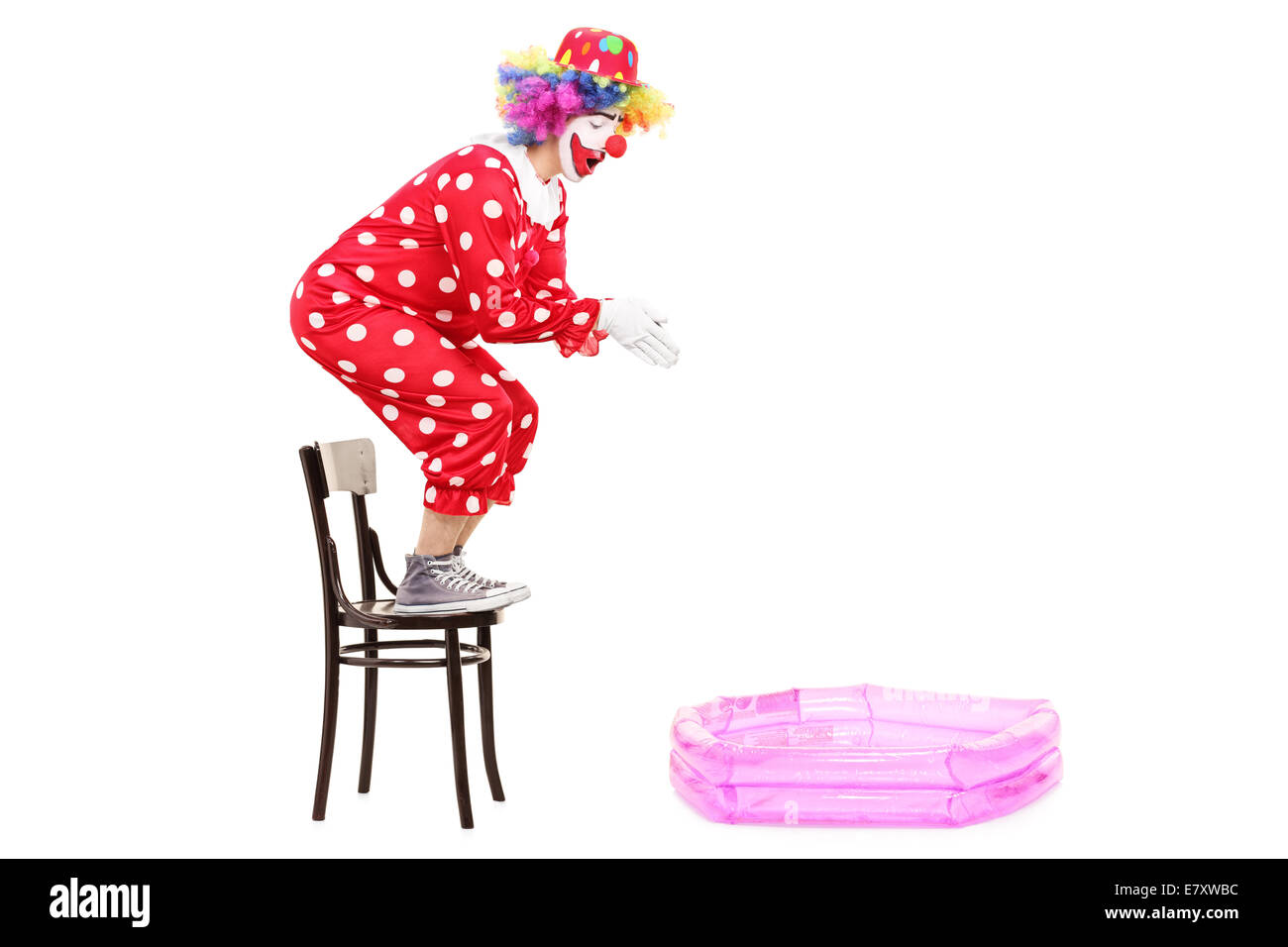 Male clown preparing to jump into a small pool isolated on white background Stock Photo