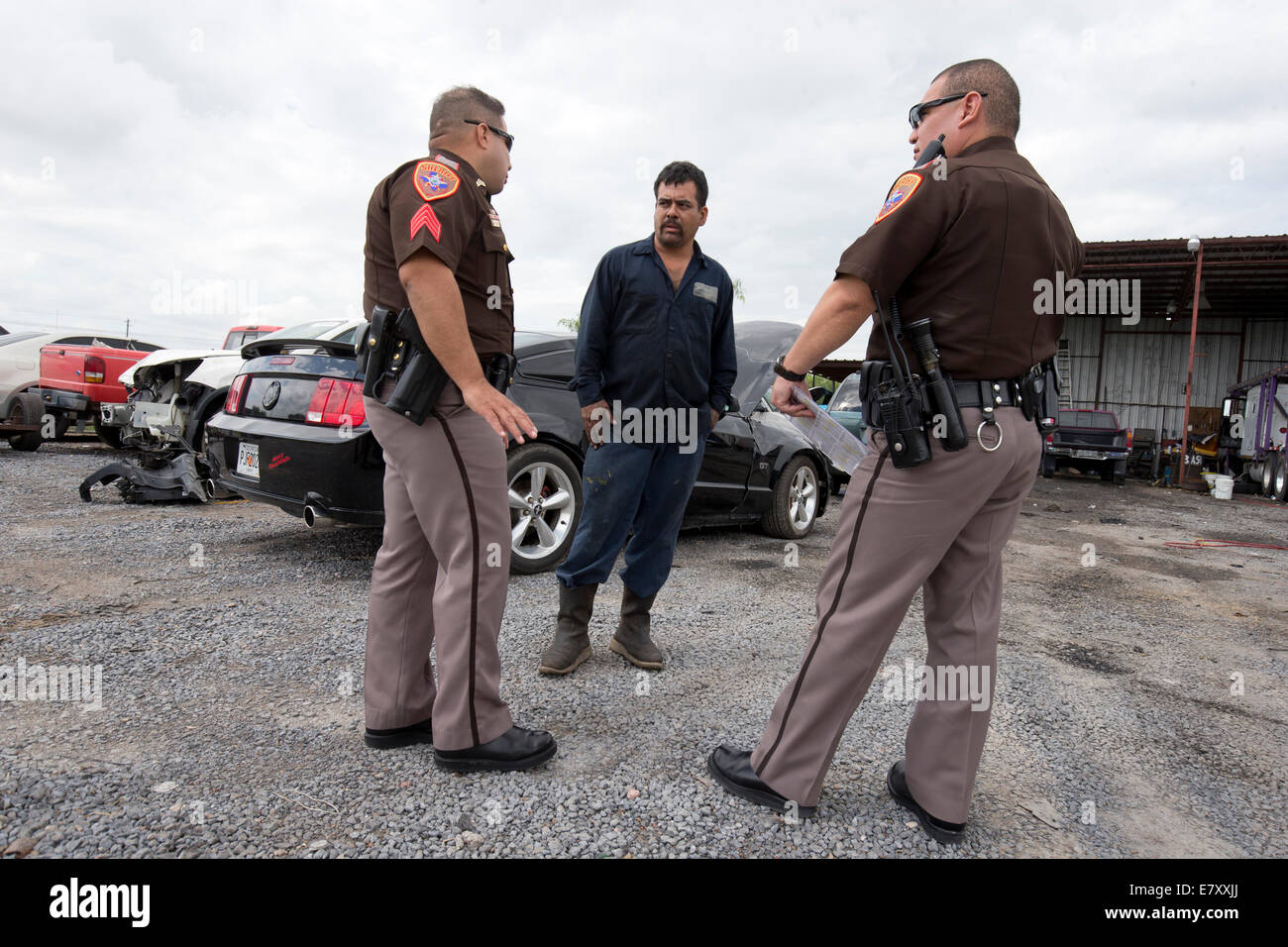 Brownsville, TX USA. 25th Sept, 2014.  Cameron CountySheriff's deputies check for information on a stolen car at one of hundreds of 'transportes' repairs shops in the Rio Grande Valley of Texas. Credit:  Bob Daemmrich/Alamy Live News Stock Photo
