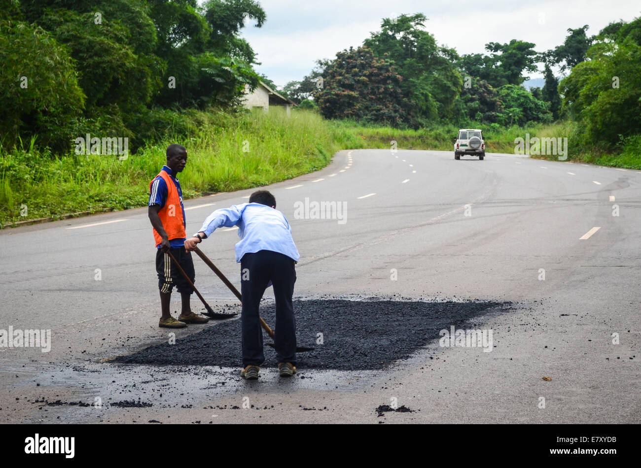 Congolese and Chinese workers re-paving the new tar road from Dolisie to Pointe-Noire, Congo, in the Massif du Mayombe Stock Photo