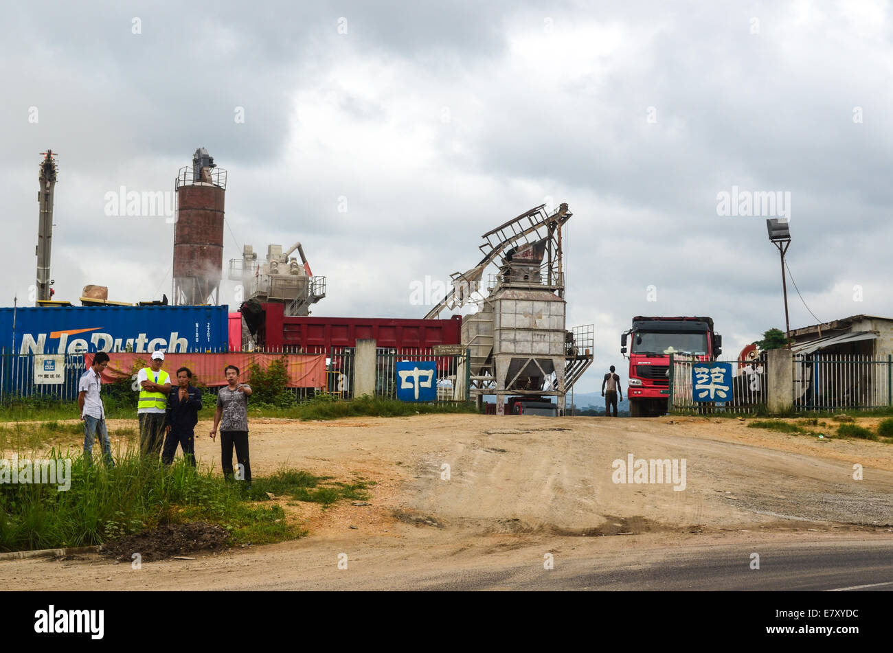 Chinese men standing in front of their asphalt plant on the construction of the road Pointe-Noire / Dolisie in Congo Stock Photo
