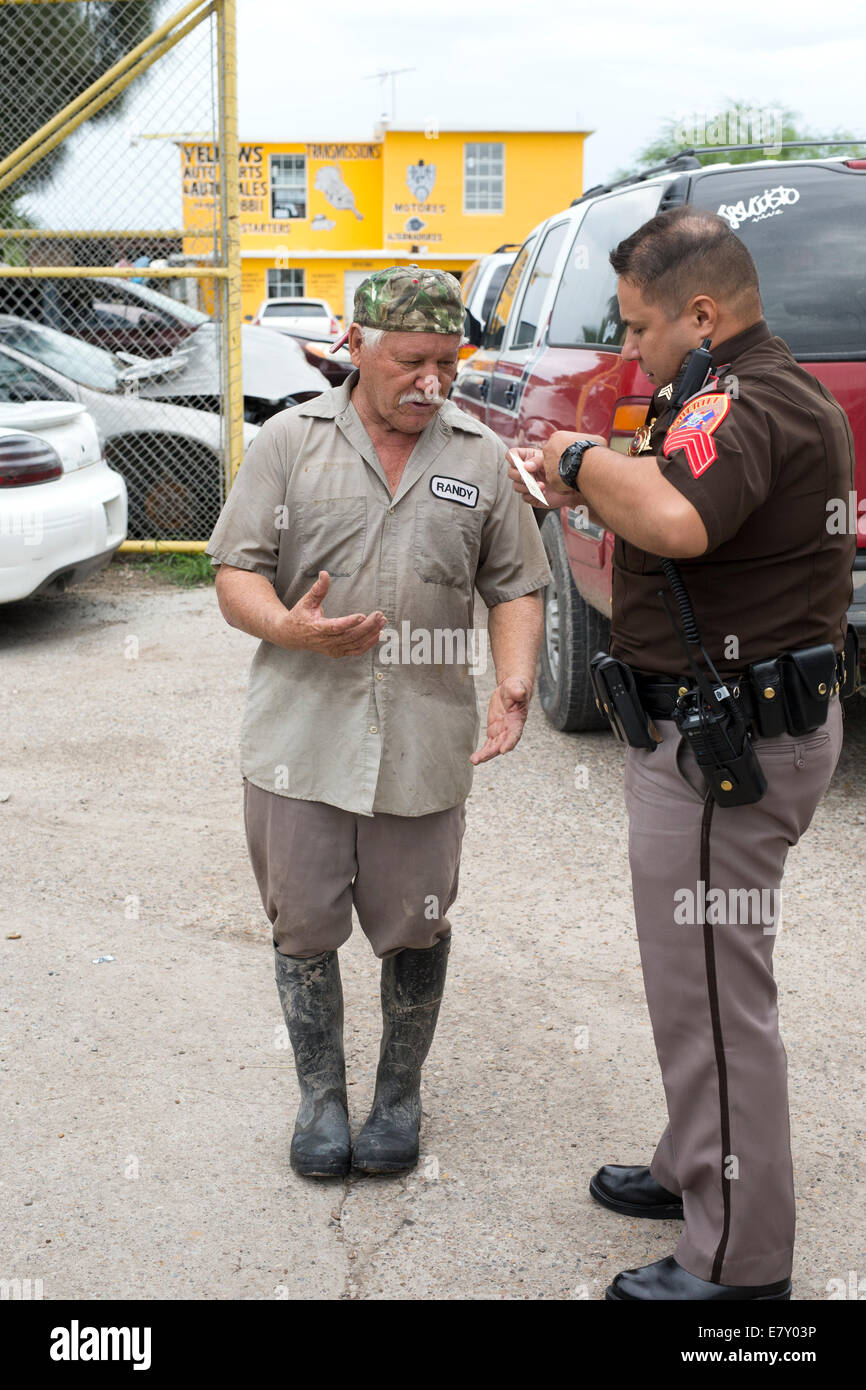 Brownsville, TX USA 25SEP14: Cameron County sheriff's officers question a wrecking yard employee about a stolen vehicle during routine operations in south Texas at Brownsville, TX. Credit:  Bob Daemmrich/Alamy Live News Stock Photo