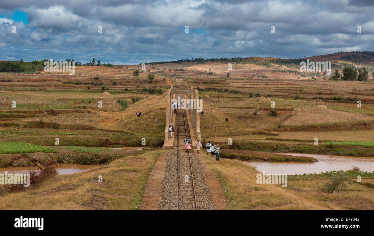 Malagasy people from the countryside cross a railroad bridge on the way to work and school on May 25, 2014 in Madagascar. Stock Photo