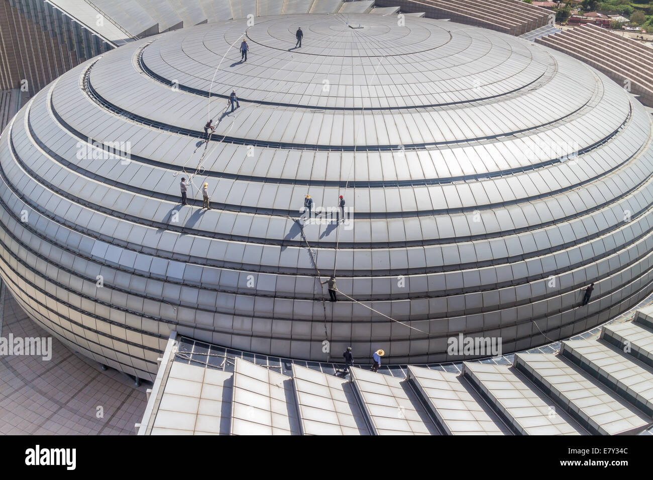 Workers tied with safety harness carefully conduct maintenance duties on the roof of the newly constructed African Union Hall on Stock Photo