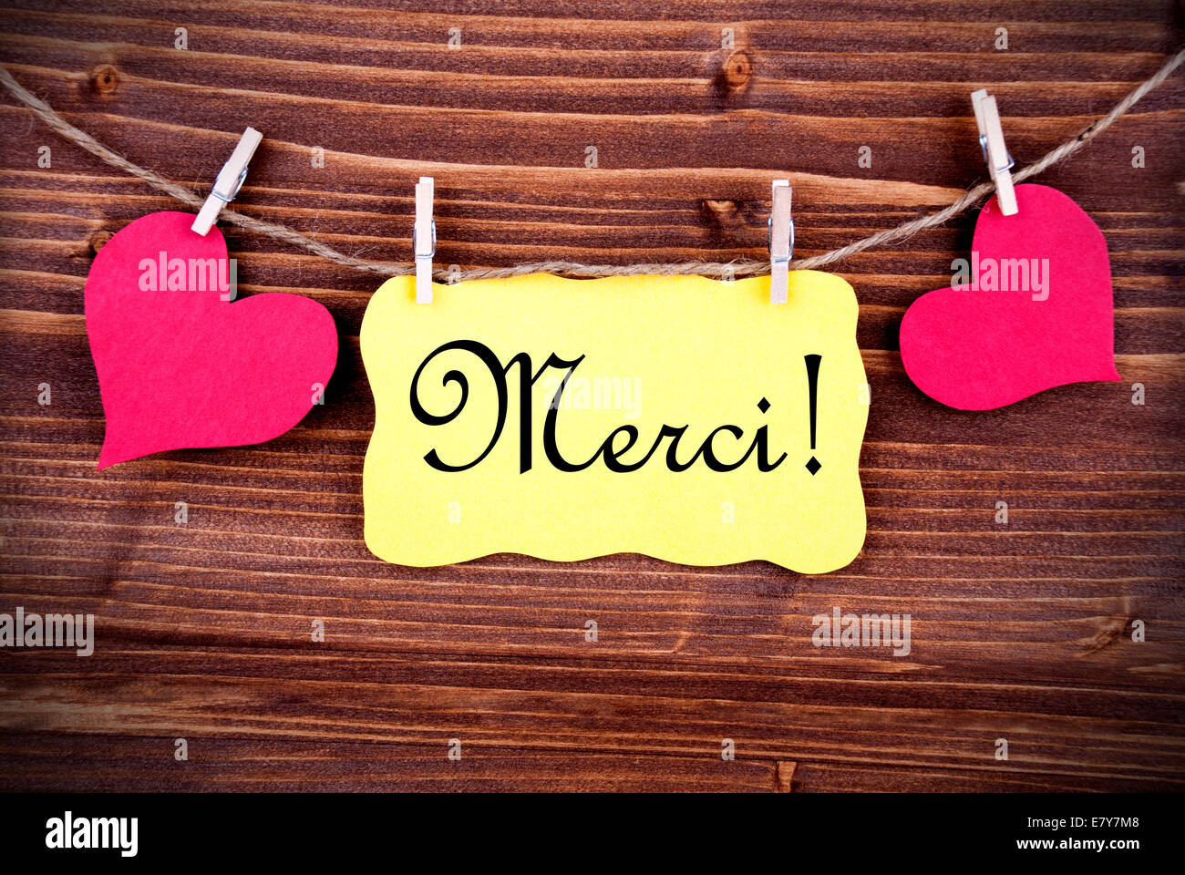The French Word Merci, which means Thanks, on a Yellow Tag, framed by