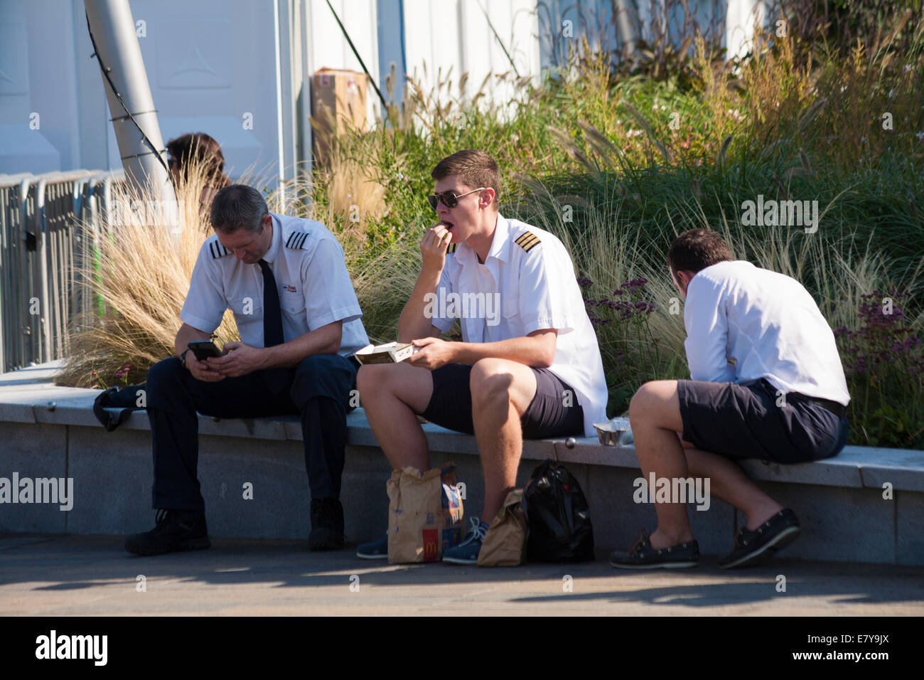 pilots sitting on wall eating at Greenwich, London in September Stock Photo