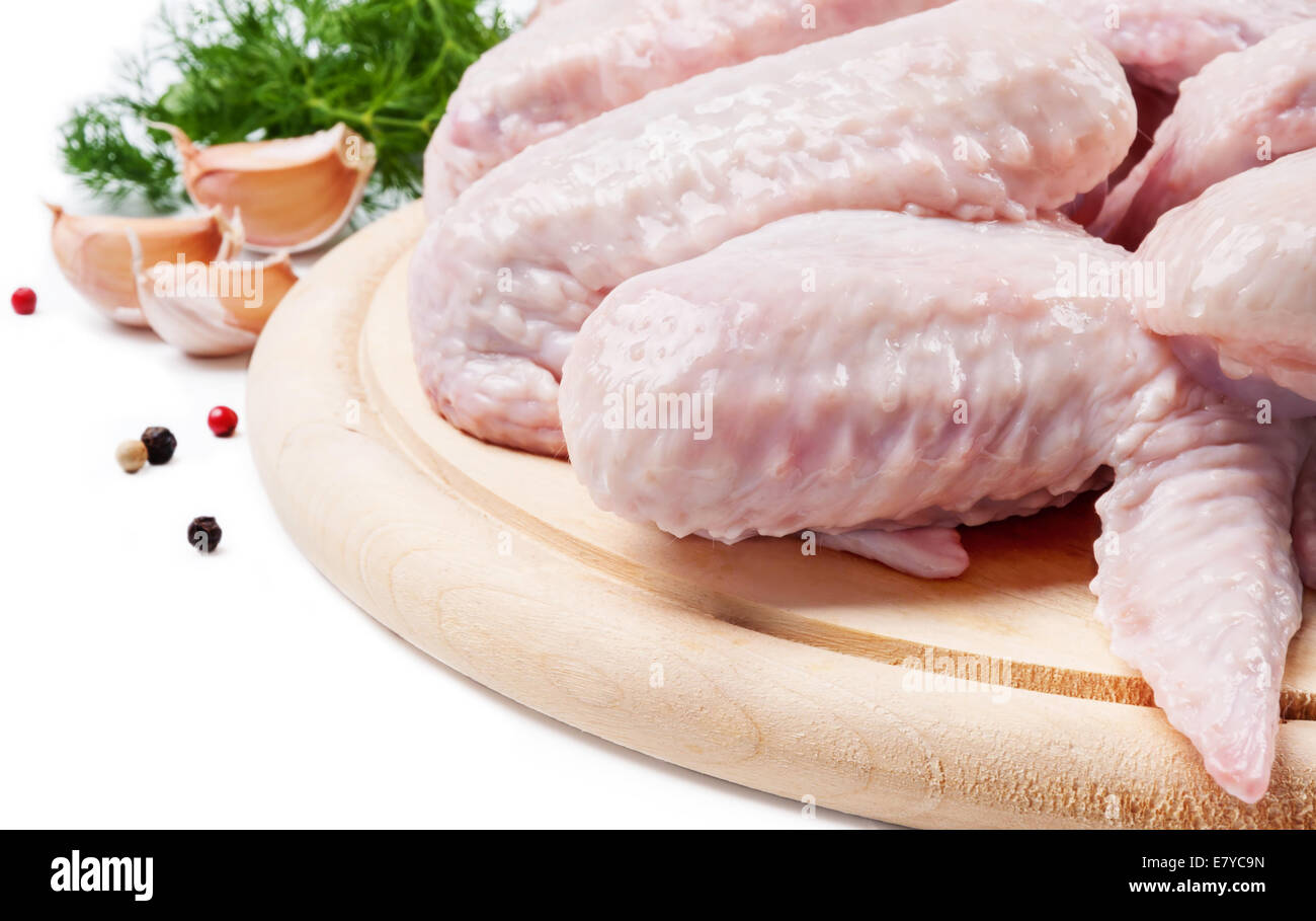Raw chicken wings on a wooden  board with dill and garlic Stock Photo