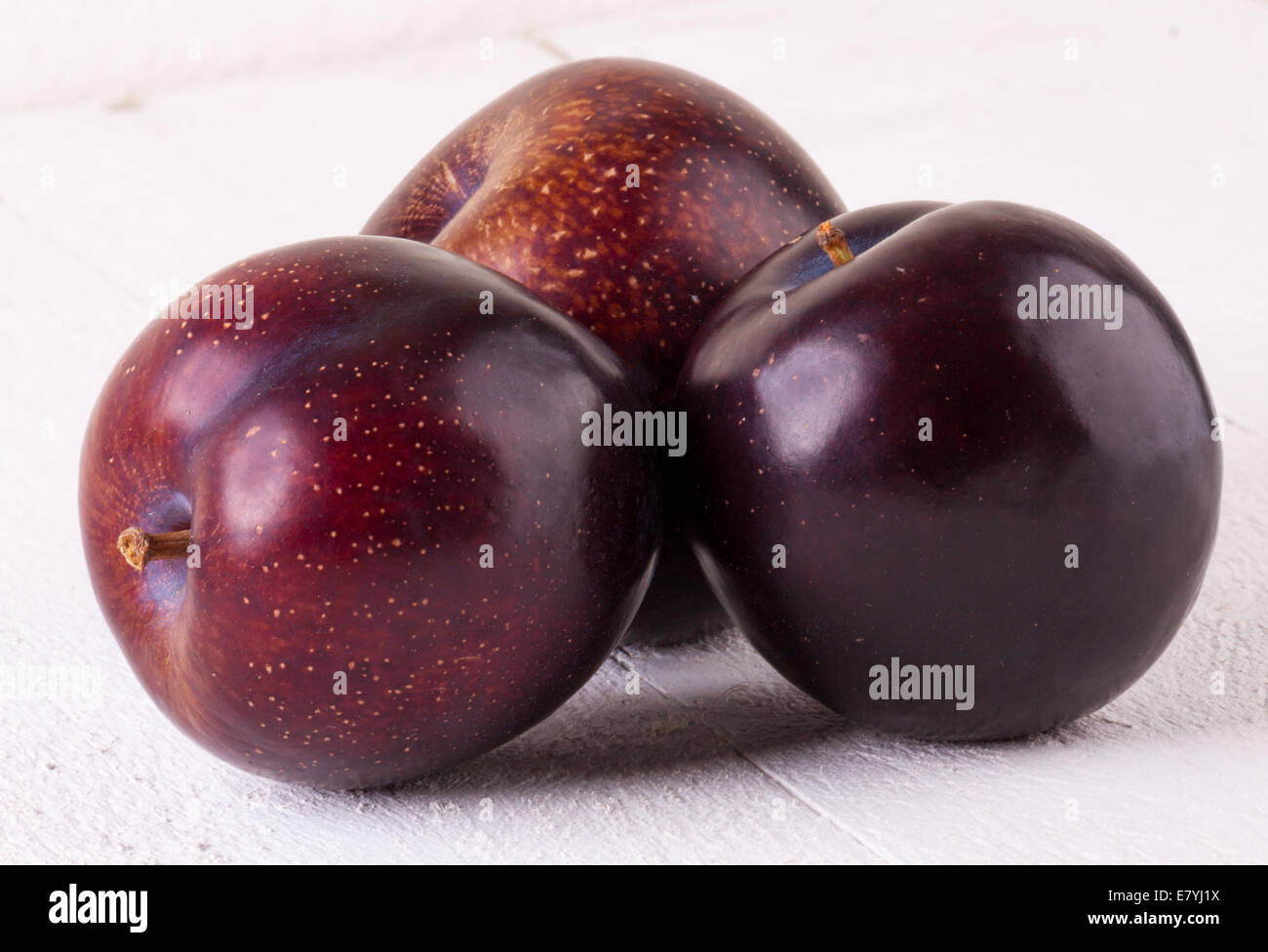 Fresh ripe red juicy appetizing plum close up view with the stalk facing the camera in a concept of healthy eating and diet with Stock Photo