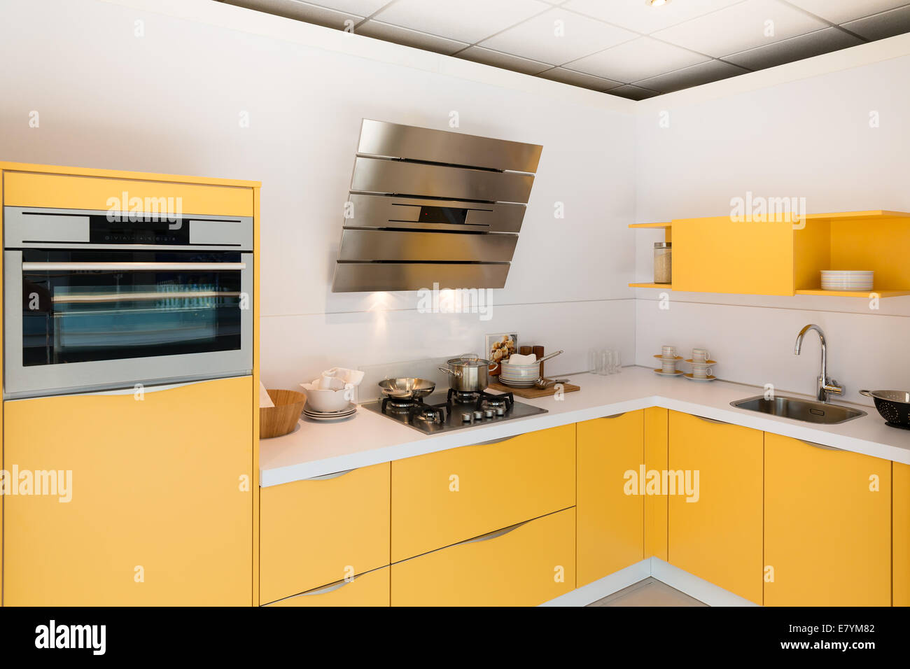 Modern yellow kitchen with steel oven and hood Stock Photo