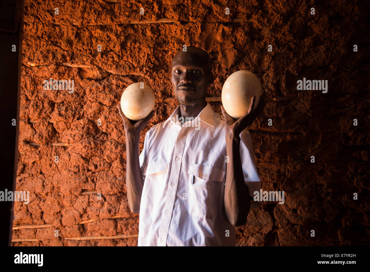 An Unidentified man holds up illegal Ostrich eggs he is trying to sell on the black market in Wamba, Kenya, September 26, 2013. Stock Photo