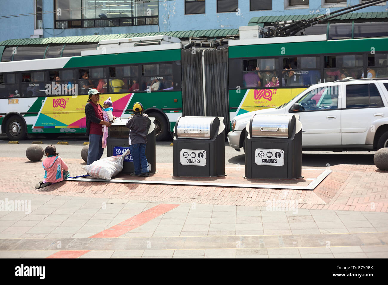 Woman with children standing beside trash cans located on Plaza del Teatro in the city center in Quito, Ecuador Stock Photo