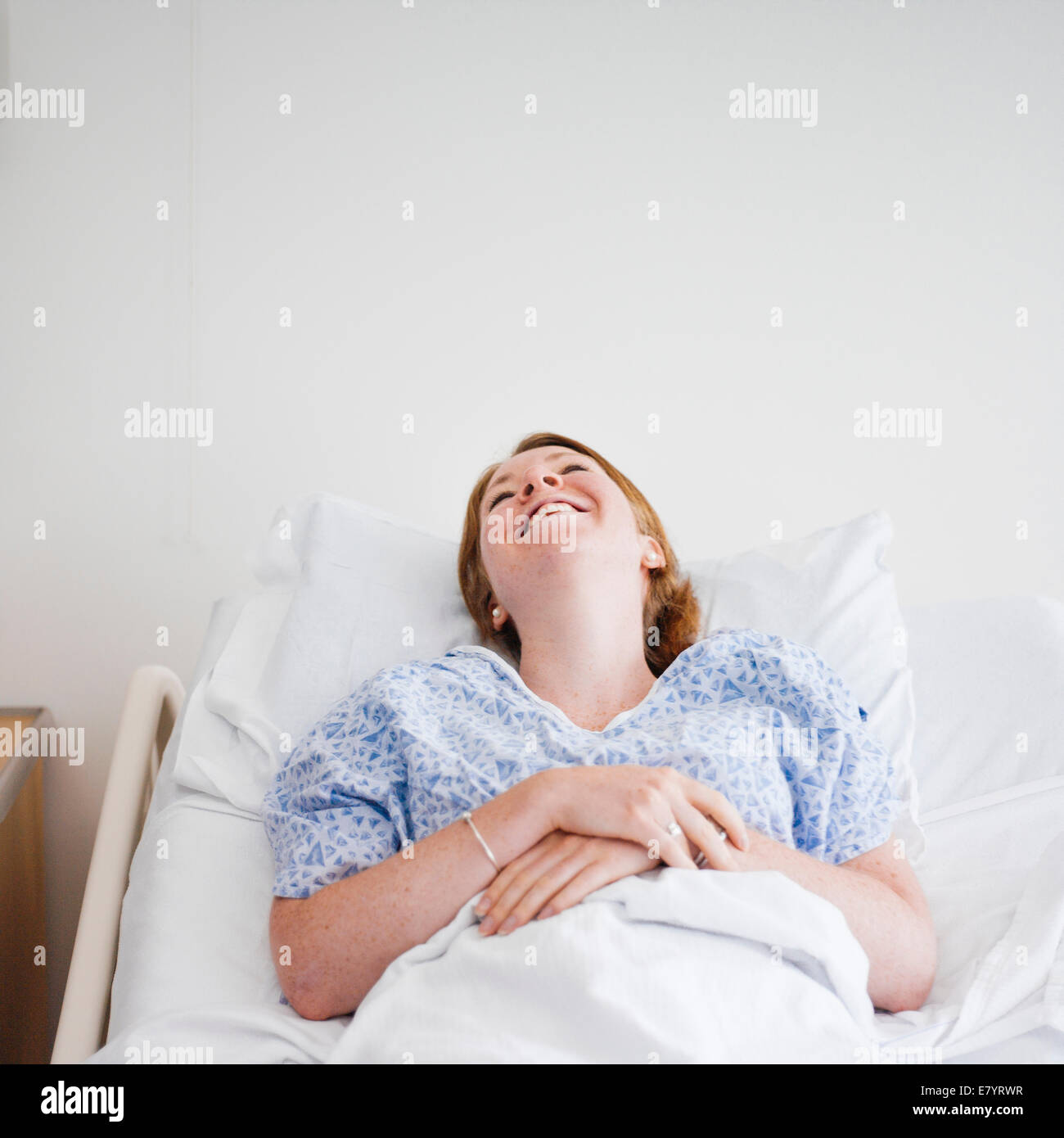 View of woman lying in hospital bed and laughing Stock Photo