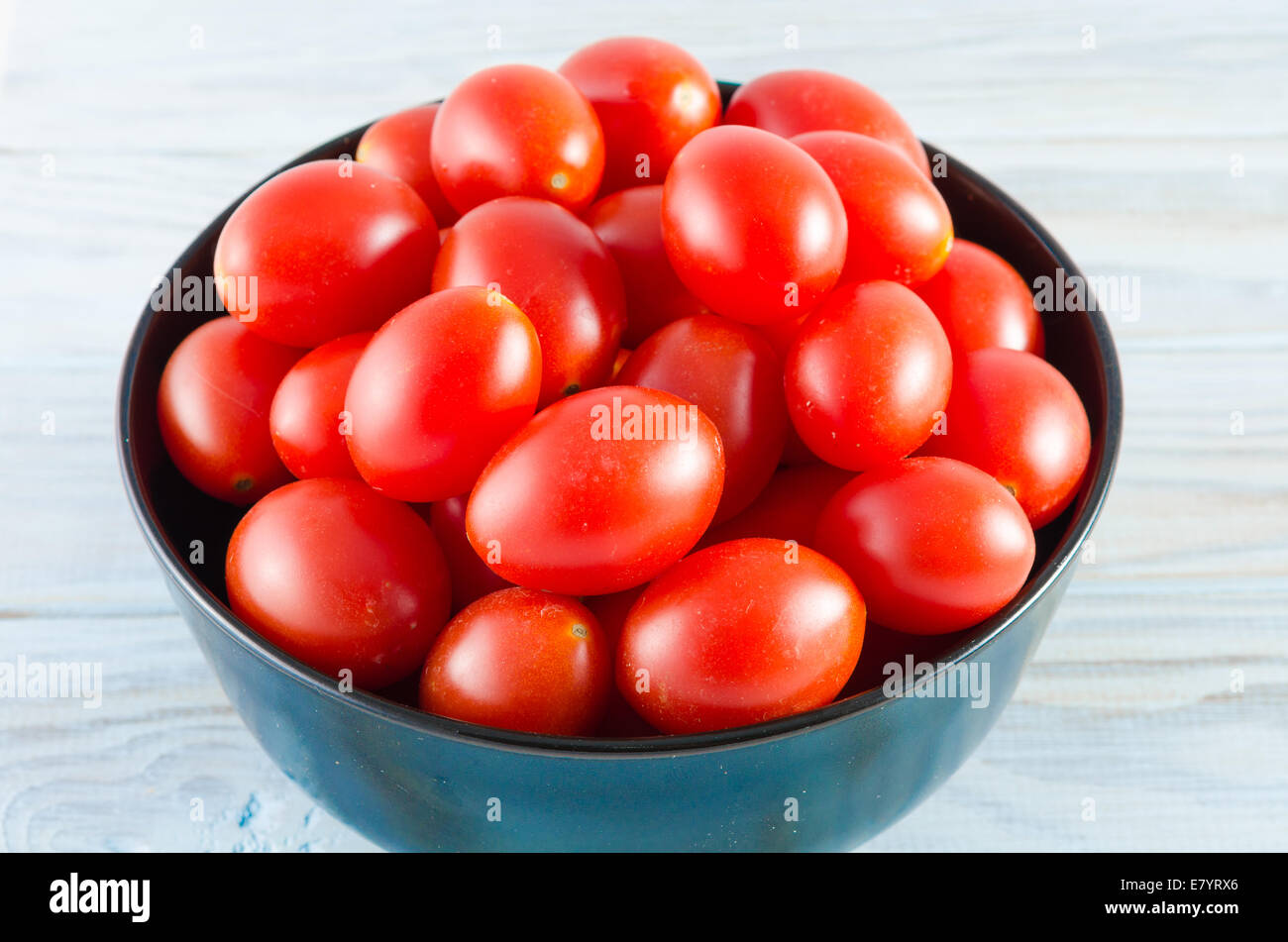 cherry tomatoes in a black bowl on aged wooden table Stock Photo - Alamy