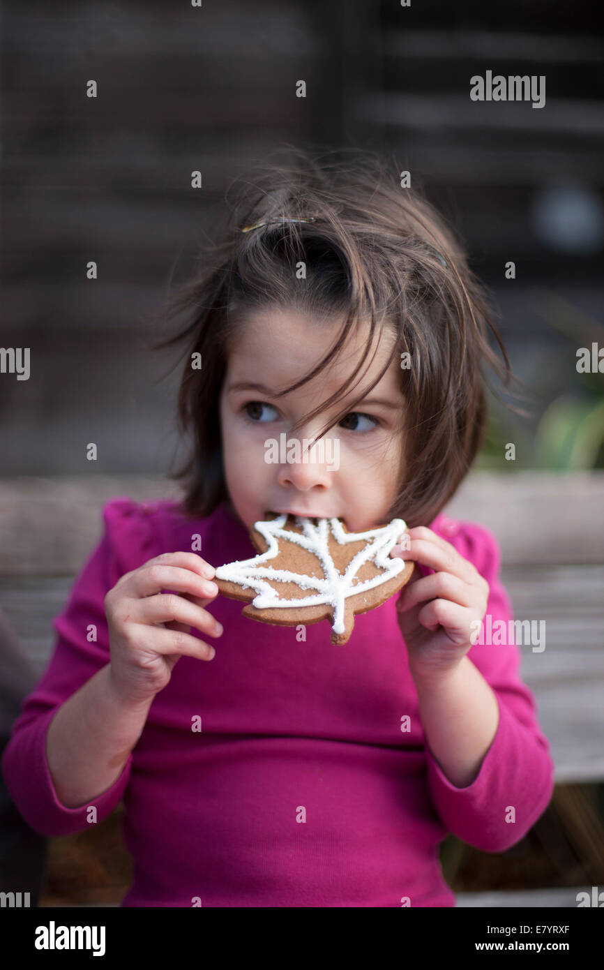Portrait of girl (4-5 years) eating cookie Stock Photo