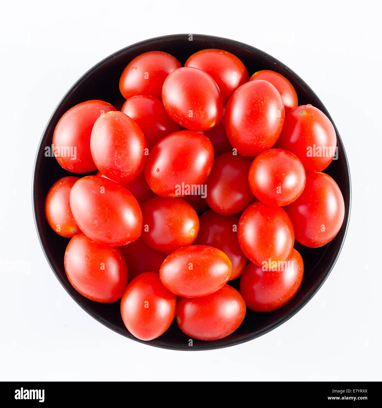 cherry tomatoes in a black bowl isolated on white Stock Photo - Alamy