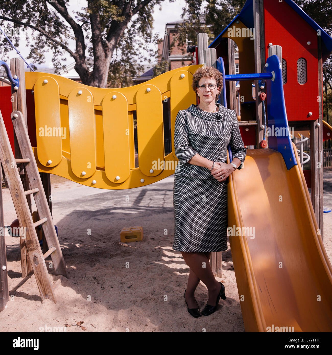 Middle-aged woman leaning on slide at playground Stock Photo