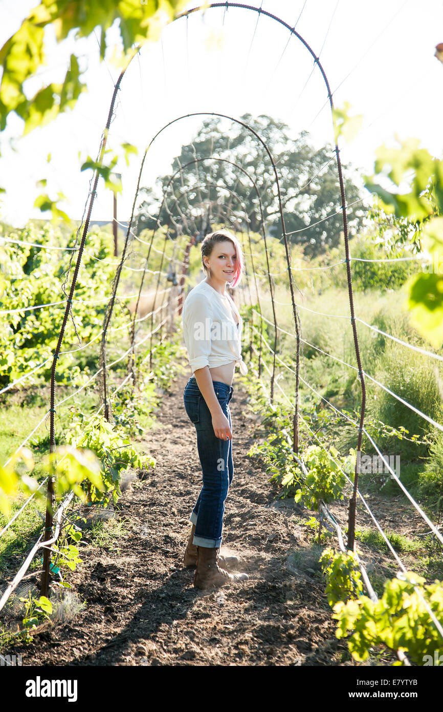Young woman standing in pergola archway Stock Photo