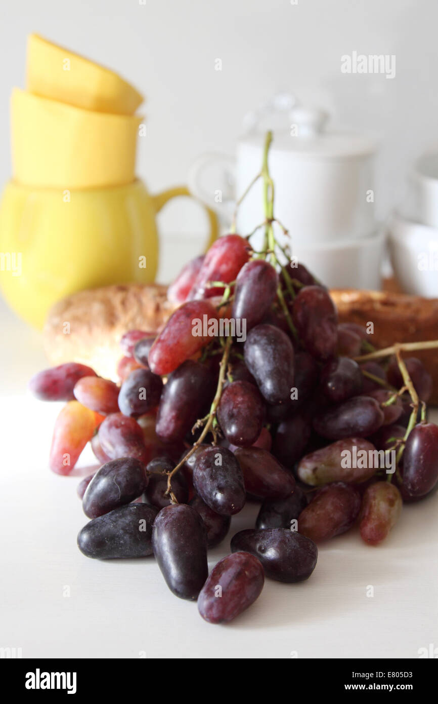 Grapes on a background of bread and dishes. Stock Photo
