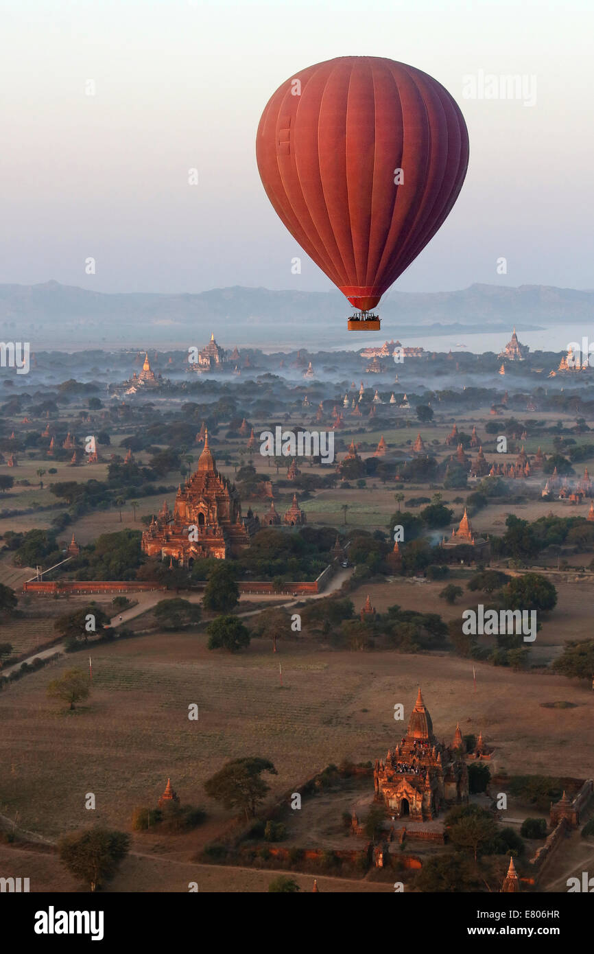 Hot air balloon flying over the temples of the Archaeological Zone in Bagan in Myanmar. Stock Photo