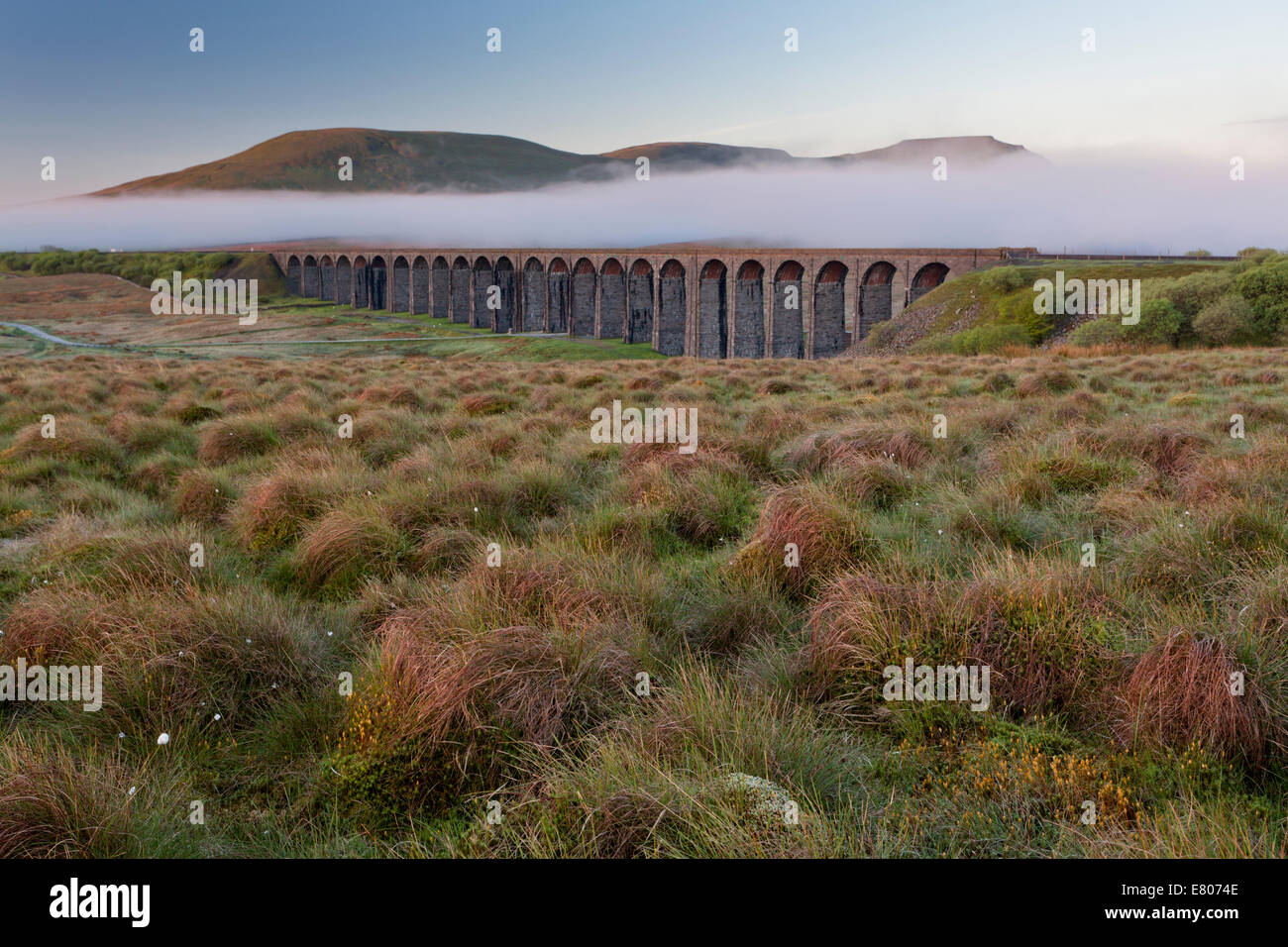 Ribblehead Viaduct in the springtime with a blanket of mist behind Stock Photo