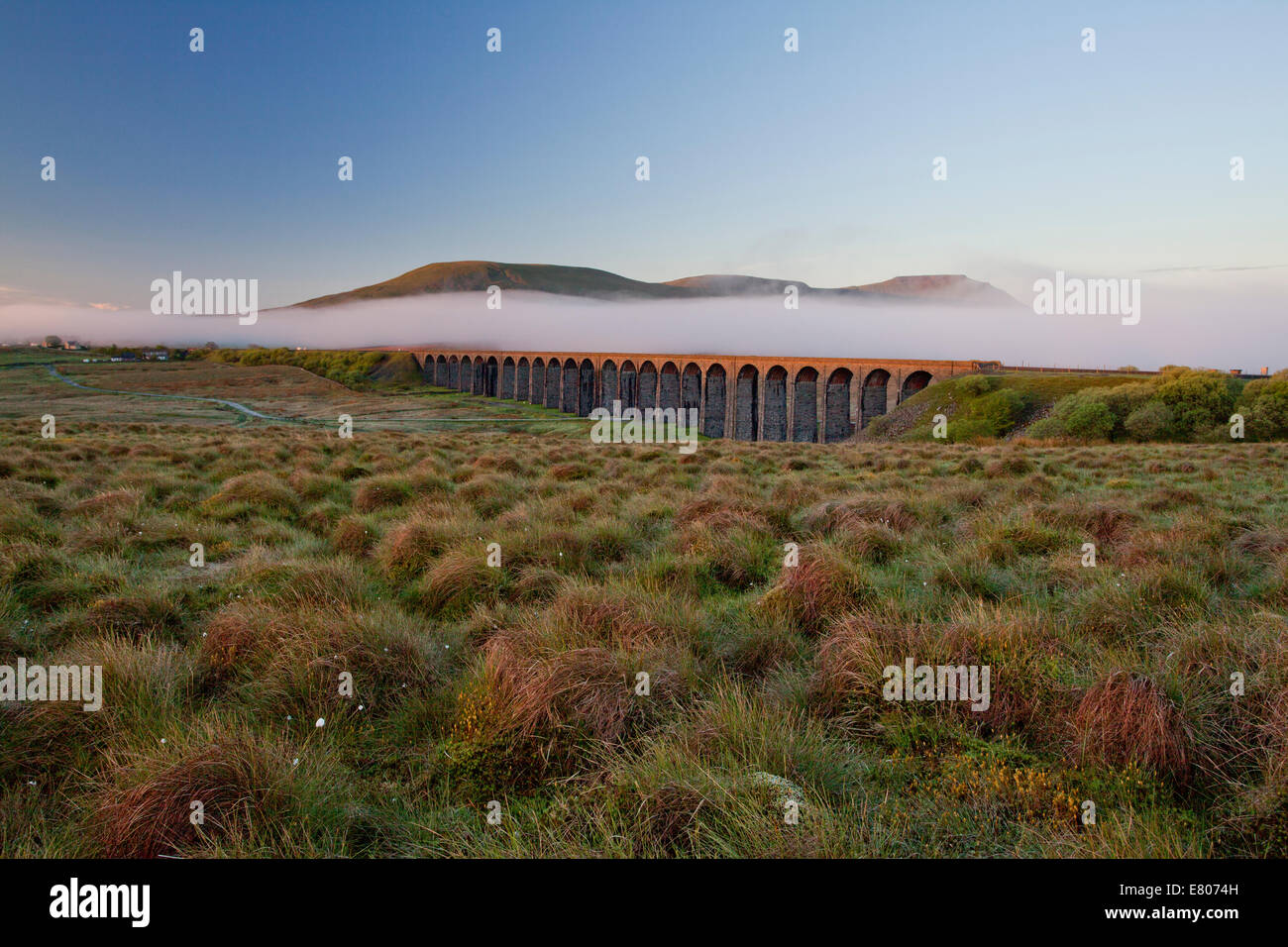 Ribblehead Viaduct in the springtime with a blanket of mist behind Stock Photo