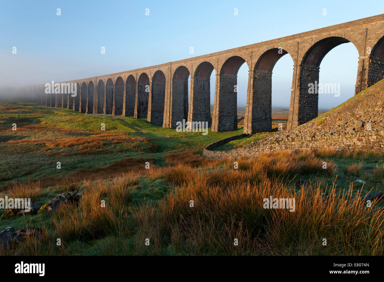 Ribblehead Viaduct in the springtime with a blanket of mist behind Stock Photo