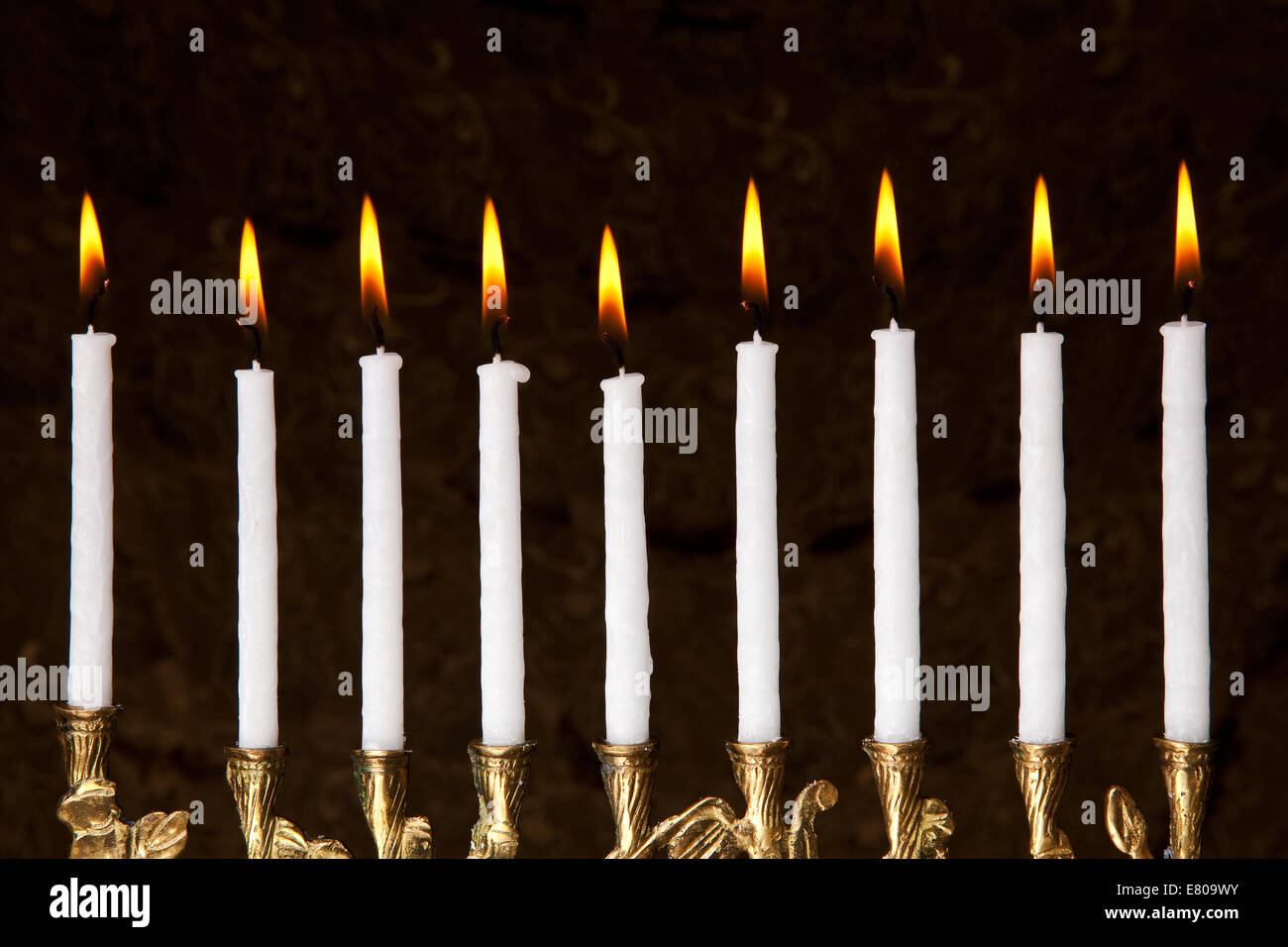 burning hanukkah candles in a menorah on black background Stock Photo