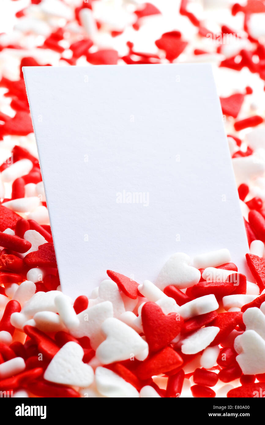 Valentine red and white heart sprinkles background with card Stock Photo