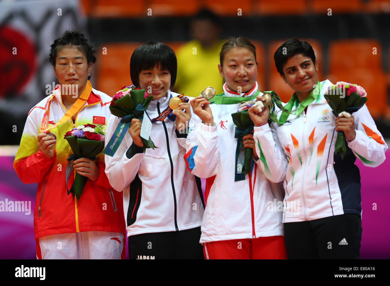 Incheon, South Korea. 27th Sep, 2014. Gold medalist Watari Rio (2nd L) of Japan, silver medalist Xiluo Zhuoma (1st L) of China and bronze medalists Jakhar Geetika (1st R) of India and Sukhee Tserenchimed of Mongolia pose during the awarding ceremony of the women's freestyle 63 kg contest of wrestling at the 17th Asian Games in Incheon, South Korea, Sept. 27, 2014. Watari Rio defeated Xiluo Zhuoma 3-1 and claimed the title. © Fei Maohua/Xinhua/Alamy Live News Stock Photo