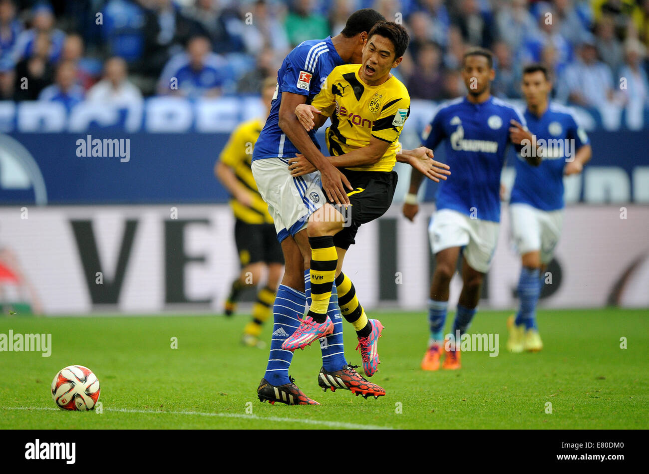 Gelsenkirchen, Germany. 27th Sep, 2014. Dortmund's Shinji Kagawa (R) vies for the ball with Schalke's Joel Matip (L) during the German Bundesliga soccer match between FC Schalke 04 and Borussia Dortmund at Veltins Arena in Gelsenkirchen, Germany, 27 September 2014. Photo: Jonas Guettler/dpa (ATTENTION: The DFL limits the utilisation and publication of sequential pictures on the internet and other online media during the match on 15 pictures per game.)/dpa/Alamy Live News Stock Photo