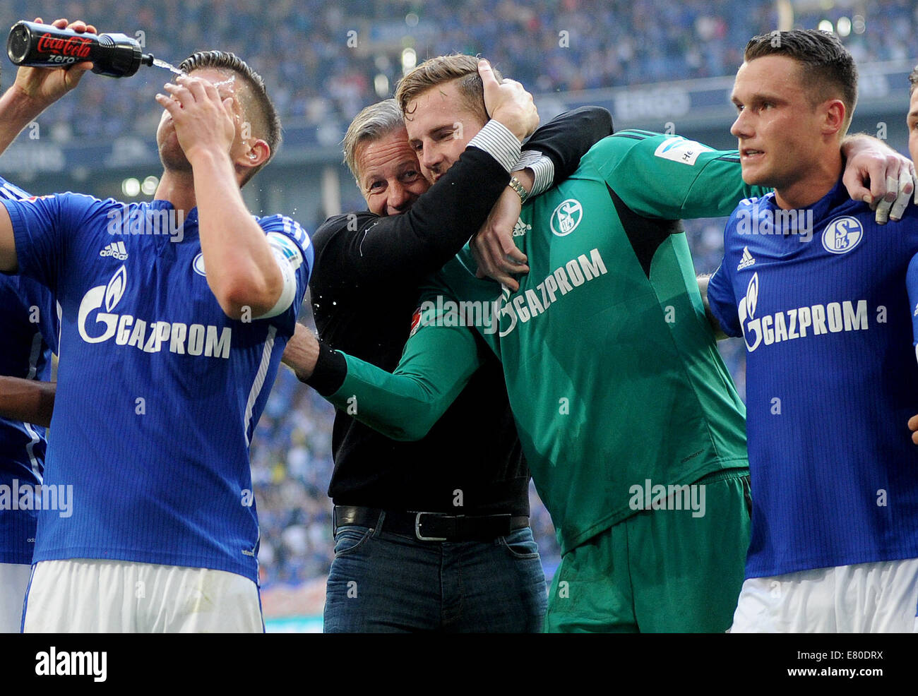 Gelsenkirchen, Germany. 27th Sep, 2014. Schalke's head coach Jens Keller (2-L) hugs goalkeeper Ralf Faehrmann (2-R) as Klaas-Jan Huntelaar (L) splashes his face with water after the German Bundesliga soccer match between FC Schalke 04 and Borussia Dortmund at Veltins Arena in Gelsenkirchen, Germany, 27 September 2014. Photo: Jonas Guettler/dpa (ATTENTION: The DFL limits the utilisation and publication of sequential pictures on the internet and other online media during the match on 15 pictures per game.)/dpa/Alamy Live News Stock Photo